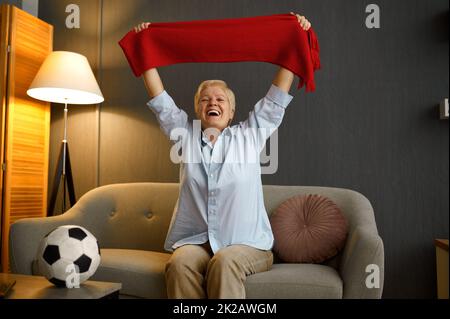 Football anziano e gioioso che tiene la sciarpa sopra la testa Foto Stock