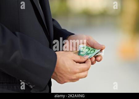 Realizzare un profitto. Immagine ritagliata di un uomo d'affari che conta denaro. Foto Stock