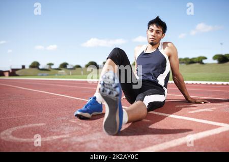 Questo è il mio tappeto erboso. Un giovane atleta che si appoggia su una pista da corsa. Foto Stock