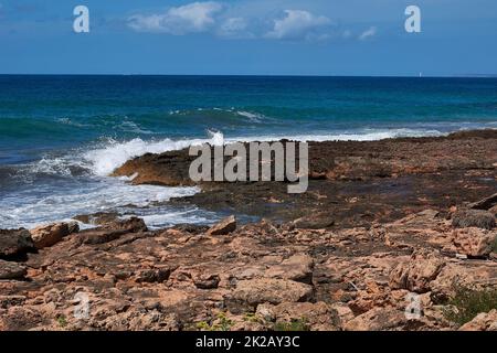 Rocce sulla riva colpite dall'onda Foto Stock