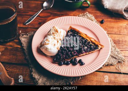 Fetta di torta di serviceberry e due cucchiai di gelato alla vaniglia Foto Stock