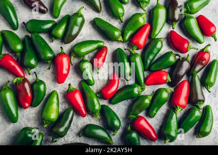 Peperoni Jalapeno colorati su fondo in cemento Foto Stock