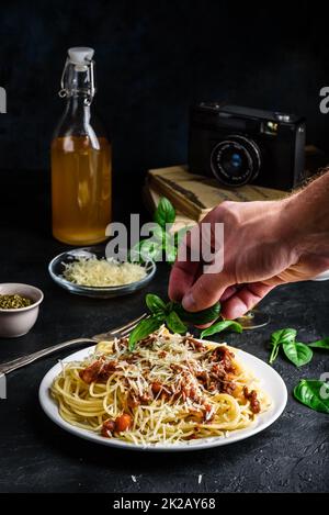 Spaghetti con salsa bolognese e parmigiano grattugiato Foto Stock