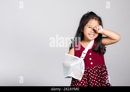 Piccola ragazza cute capretto 3-4 anni osso della mano rotto da incidente con stecca del braccio in studio sparato isolato Foto Stock