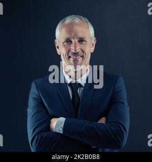 HES molto competente a quello che fa. Ritratto di studio di un uomo d'affari maturo su sfondo scuro. Foto Stock