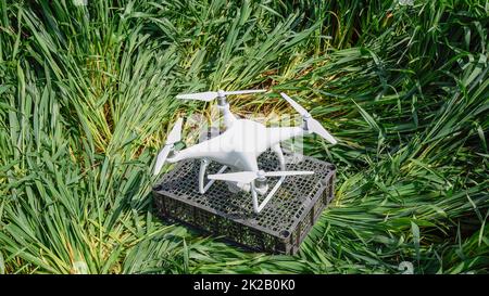 Quadrocopters su una scatola di plastica in erba Foto Stock