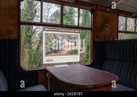 Un poster che pubblicizza Bodmin e Wenford Heritage Rail dall'interno di una carrozza a vapore GWR. Cornwall, Regno Unito Foto Stock