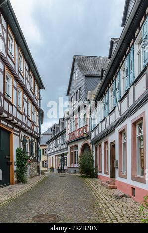 Strada con case a graticcio e ciottoli a Eltville am Rhein, Rheingau, Hesse, Germania Foto Stock