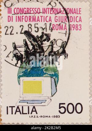 Foto di un francobollo italiano con un'illustrazione di un computer la terra e una statua di un carro del Palazzo di Giustizia di Roma 1983 Foto Stock