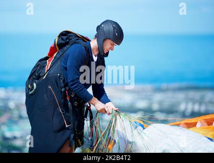 È tutto abbastanza stretto. Scatto di un uomo pronto per il parapendio. Foto Stock