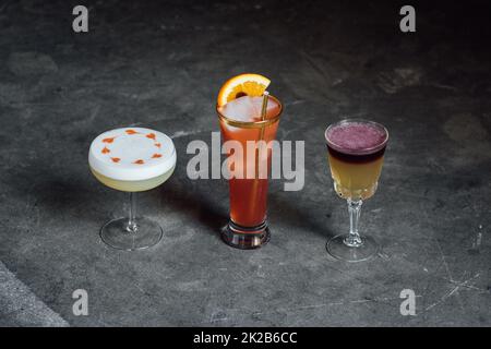 collezione di tre cocktail, sours whisky, cuori disegnati con amaretti su schiuma albume Foto Stock