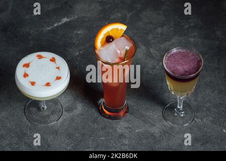 collezione di tre cocktail, sours whisky, cuori disegnati con amaretti su schiuma albume Foto Stock