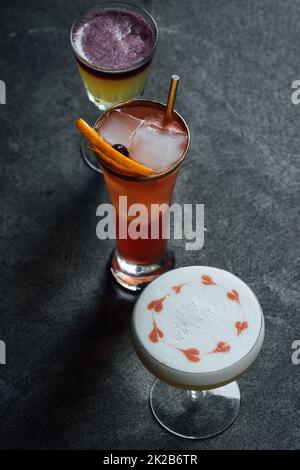 collezione di tre cocktail, sours whisky, cuori disegnati con amaretti su schiuma albume Foto Stock