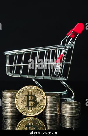 Moneta Bitcoin nel carrello della spesa su sfondo nero Foto Stock