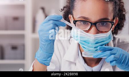 Questo test dovrebbe farlo. Shot di un giovane scienziato che analizza i campioni in un laboratorio. Foto Stock