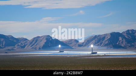 Vista su una centrale solare situata su una pianura di fronte ad un massiccio montano. Foto Stock