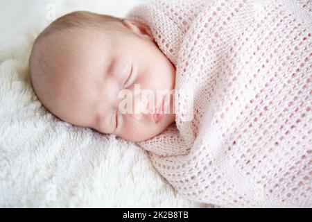 Dolce innocenza. Una bella bambina che dorme mentre si avvolge in una coperta. Foto Stock