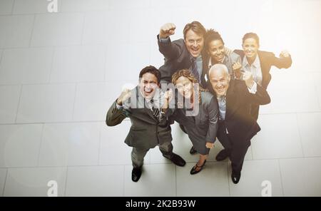 CE l'abbiamo fatta. Ritratto ad angolo alto di un gruppo di uomini d'affari che si acclamano nella lobby dell'ufficio. Foto Stock