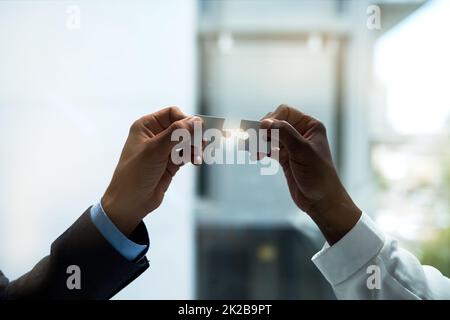 Mettere tutto insieme. Primo piano di due inidentificabili uomini d'affari che tengono insieme pezzi di puzzle. Foto Stock