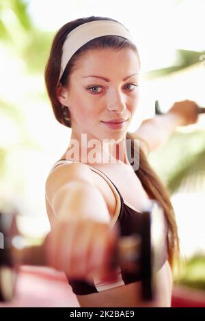 Lavoro per il corpo che voglio. Shot di una giovane donna attraente che si sta allenando con manubri. Foto Stock