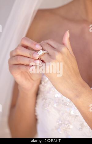 È perfetto. Bella sposa nel suo abito da sposa che tocca il suo anello di nozze. Foto Stock