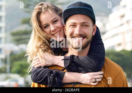 Ceneri tutto ciò di cui ha mai bisogno. Ritratto di una giovane coppia affettuosa che passa il tempo insieme all'aperto. Foto Stock