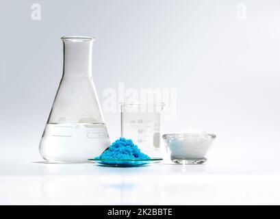 Ingrediente chimico cosmetico su tavola bianca da laboratorio. Solfato di rame (II), cera microcristallina, alcool. Ingrediente chimico per prodotti cosmetici e da bagno. Vista laterale Foto Stock