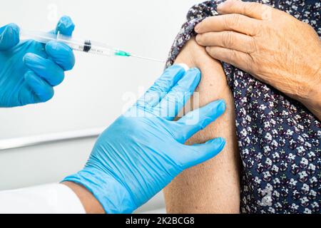 Anziana anziana anziana asiatica che riceve il vaccino per il coronavirus 19 o il vaccino per il coronavirus da parte del medico effettua l'iniezione. Foto Stock