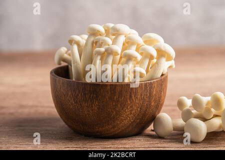 Shimeji, funghi bunapi freschi bianchi dell'Asia in ciotola di legno. Foto Stock