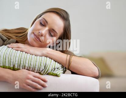 Un pisolino pomeridiano. Una donna attraente che fa un pisolino sul divano a casa. Foto Stock