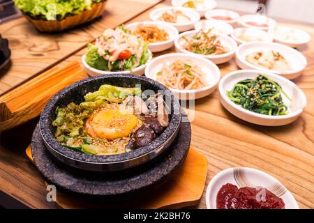 Piatto tradizionale coreano - bibimbap riso misto con verdure includono manzo, uova fritte e sottaceti set Foto Stock