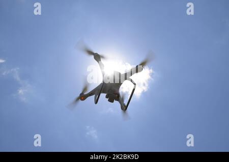 Drone DJI Phantom 4 in volo. Quadrocopter contro il cielo blu con nuvole bianche. Il volo del copter nel cielo. Foto Stock