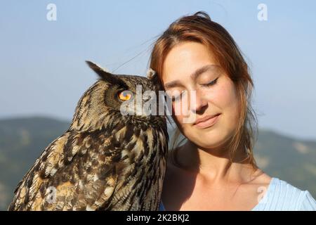 Affettuoso falconer con un gufo di aquila all'aperto Foto Stock