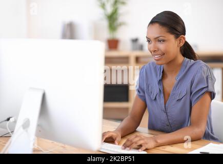 Utilizzo della tecnologia per portare a termine il lavoro. Scatto corto di una giovane donna d'affari attraente utilizzando un dispositivo wireless. Foto Stock