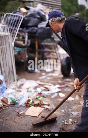 Mantenere pulita la nostra città. Scatto ritagliato di un pulitore di strada spazzatura su spazzatura. Foto Stock