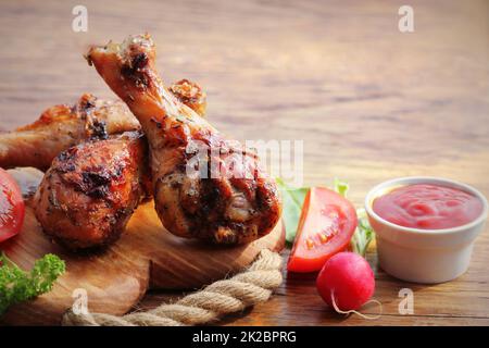Pollo alla griglia gambe sul bordo di taglio.cena rustica sfondo Foto Stock