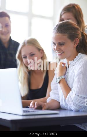 La tecnologia semplifica l'apprendimento. Un gruppo di ragazze adolescenti che lavorano insieme su un notebook in aula. Foto Stock