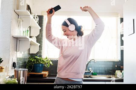 Non riesco ad immaginare la vita senza musica. Scatto corto di una giovane donna che ascolta la musica attraverso le sue cuffie. Foto Stock