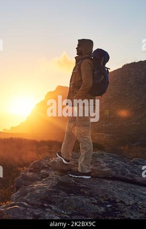 La meraviglia del mondo. Scatto di un escursionista sulla cima di una montagna che si gode la vista del sole del mattino. Foto Stock