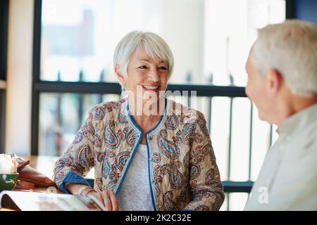 Si godono i loro colloqui. Shot di una coppia sorridente che si riunisce in un caffè. Foto Stock