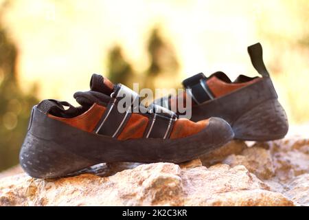 Il paio perfetto di scarpe da arrampicata. Scarpe da arrampicata sdraiate su una roccia all'aperto. Foto Stock