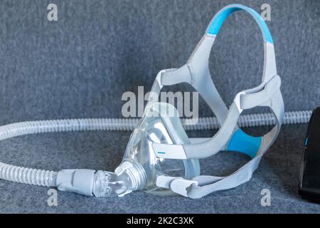 La maschera CPAP contro l'apnea ostruttiva del sonno sul cuscino aiuta i pazienti come maschera respiratore e clip per la bretella di fissaggio per la respirazione di farmaci con una macchina cpap contro il russamento e disturbi del sonno per respirare più facile Foto Stock