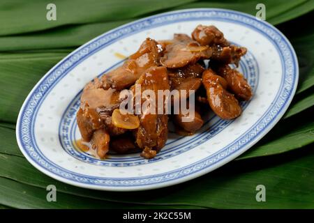 Pollo all'aglio allo Stir dolce e agrodolce, menu del ristorante cinese asiatico. Servito su piatto di ceramica ovale Foto Stock