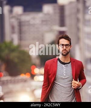 Camminare per le strade con stile. Scatto di un bel giovane uomo che fa una passeggiata attraverso la città. Foto Stock