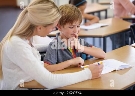 Arricchire le giovani menti desiderose. Una giovane insegnante nella sua classe. Foto Stock