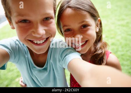 Selfie fratello. Scatto di un fratello e di una sorella giovani che prendono un selfie in giardino. Foto Stock