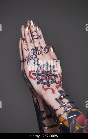 Autoespressione creativa. Un taglio corto di mani tatuate. Foto Stock