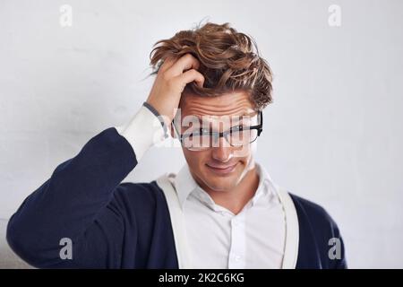 Im confuso.... Un giovane uomo con capelli disordinati che guarda perplesso. Foto Stock