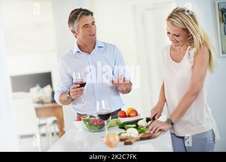 Le coppie che cucinano insieme, rimangono insieme. Scatto di una coppia matura che parla insieme mentre fa la cena. Foto Stock