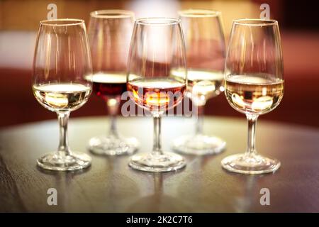 Le numerose varietà di vino. Shot di cinque bicchieri di vini diversi su un tavolo. Foto Stock